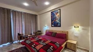 a bedroom with a bed with a red comforter at Northbound Kasol in Kasol +20 photos