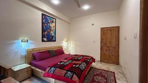 a bedroom with a bed and a painting on the wall at Northbound Kasol in Kasol