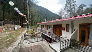 a house with a balcony next to a building at Northbound Kasol in Kasol