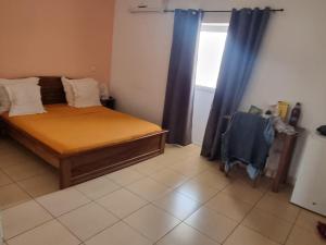 a small bedroom with a bed and a window at Hotel Bartaba in Antsiranana