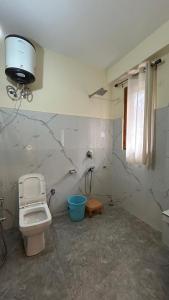 a bathroom with a toilet and a sink and a window at Northbound Kasol in Kasol