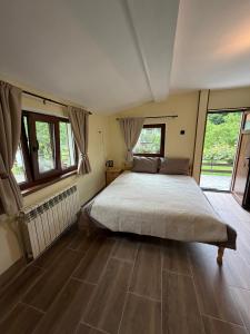 a bedroom with a large bed in a room with windows at Villa Lalka in Ribarica