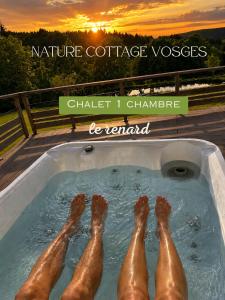 a group of people laying in a hot tub at Nature Cottage Vosges in Anould