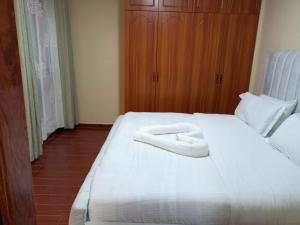 a bedroom with a bed with two white towels on it at Kaisa Studio apartments in Nairobi