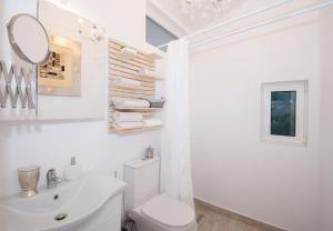 a white bathroom with a toilet and a mirror at Dream View Loft in Lithakia +60 photos