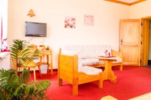 a living room with a chair and a table at Hotel Schloßblick Trebsen in Trebsen