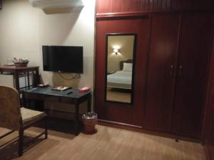 a room with a mirror and a bedroom with a bed at Hotel Grand Peshawar in Peshawar
