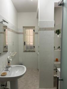 a white bathroom with a sink and a shower at La casa di Nonna Anna in Castellabate +178 photos