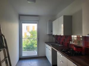a kitchen with a sink and a counter with a window at 1 chambre double privée et securisée dans un appart avec espace partagé in Saint-Denis
