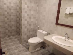 a bathroom with a toilet and a sink at Hotel Grand Peshawar in Peshawar
