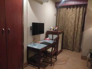 a room with a desk with a television and a desk with a chair at Hotel Grand Peshawar in Peshawar +8 photos