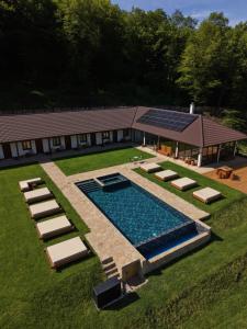an overhead view of a swimming pool with loungers and a house at Hunter's Mansion - Transylvania in Gorgan