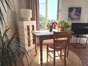 a table and chair in a room with a fireplace at Clos Florésine B&B in Venette