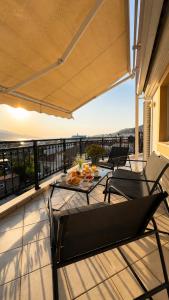 a patio with a table and chairs on a balcony at Théa Loft Premium Sunset Sea View Escape in Vathý