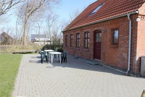 a brick building with a table and chairs on a patio at LF13030-Karby-Agerovej-44 in Karby