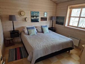 a bedroom with a bed in a log cabin at LF10999-Thyholm-Ringvejen-9 in Thyholm