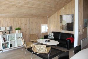 a living room with a black couch and a table at LF15018-Skals-Lynderup-Strand-4 in Skals