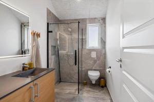 a bathroom with a shower with a toilet and a sink at 391-Harboore-Slettevej-33 in Harboør +35 photos