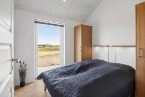 a bedroom with a bed and a large window at 391-Harboore-Slettevej-33 in Harboør