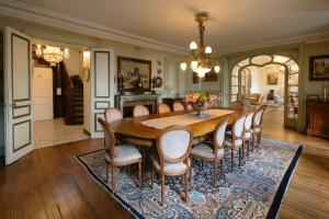 a dining room with a table and chairs on a rug at Château La Rametière in Le PARC
