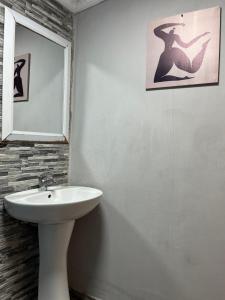 a white bathroom with a sink and a mirror at Onda Azul Back Unit A & B in Ponta do Ouro