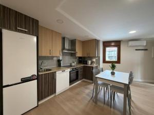a kitchen with wooden cabinets and a table and a table and chairs at casa Angelita in Mourillones