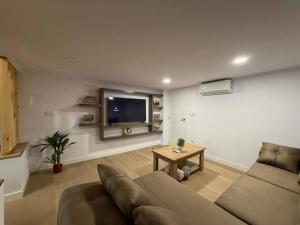 a living room with a couch and a tv at casa Angelita in Mourillones
