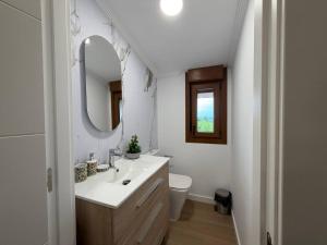 a white bathroom with a sink and a mirror at casa Angelita in Mourillones