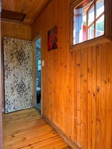 an empty room with wooden walls and a window at Onda Azul Back Unit A & B in Ponta do Ouro