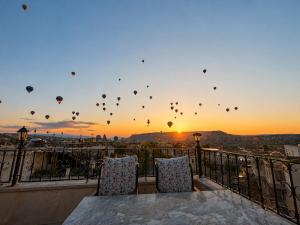 a group of hot air balloons flying in the sky at Milat Cave in Göreme