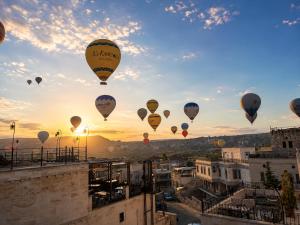 a group of hot air balloons flying in the sky at Milat Cave in Göreme