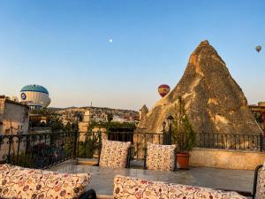 a balcony with chairs and a large rock at Milat Cave in Göreme +95 photos