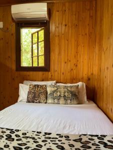 a bedroom with a bed with wooden walls and a window at Onda Azul Back Unit A & B in Ponta do Ouro +14 photos