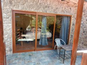 a patio with sliding glass doors and a table and chair at Casa Inka B&B in Ollantaytambo +44 photos
