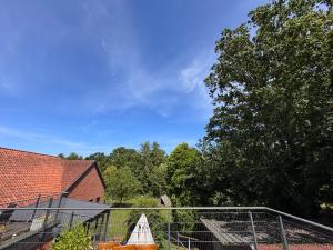 a fence in front of a house and a tree at Ferienwohnung am Rohrbach in Binnen