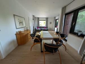 a living room with a wooden table and chairs at Seemöwe im Haus Windrose in Butjadingen