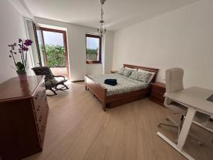 a bedroom with a bed and a desk and chairs at Rosa dei Venti - Como Lake House in Valmadrera