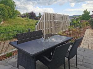 a black table with two chairs and a fence at Ferienwohnung DORFWIESE in NuÃŸbaum