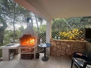 a fireplace on a patio next to a stone wall at Apartment Kordić in Sveta Nedelja