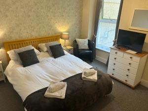 a bedroom with a large bed with towels on it at Awel Mor in Criccieth