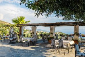 a restaurant with tables and chairs under a pergola at Hotel Panorama Piqeras in Piqeras