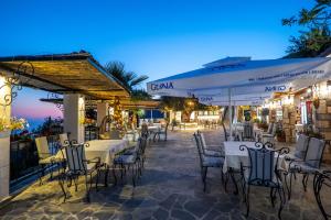 an outdoor restaurant with tables and chairs at night at Hotel Panorama Piqeras in Piqeras