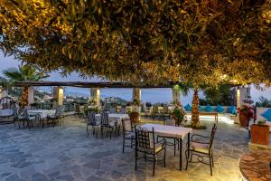 a restaurant with tables and chairs on a patio at Hotel Panorama Piqeras in Piqeras