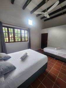 a bedroom with two beds and a ceiling fan at Hotel San Pedro de Taboga in Taboga