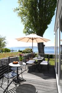 a patio with tables and chairs and an umbrella at Strandhotel Seehof in Überlingen