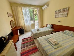 a hotel room with two beds and a window at La Zur Guest House in Ravda