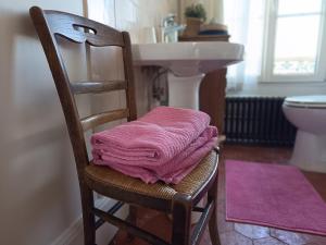 a pink towel sitting on a wooden chair in a bathroom at Clos Florésine B&B in Venette +23 photos