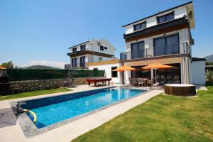 a villa with a swimming pool in front of a house at Villa Prestige 2 in Fethiye