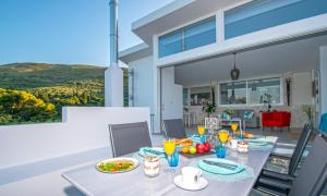 a dining room with a table with food and drinks at Dream View Loft in Lithakia