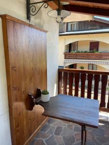 a wooden door and a table on a balcony at LI DA BIS Affittacamere in Avasinis